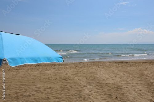 blue umbrella on the beach without people symbol of relaxation and summer vacation © ChiccoDodiFC