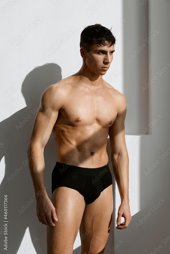 handsome male bodybuilder in black panties posing macho