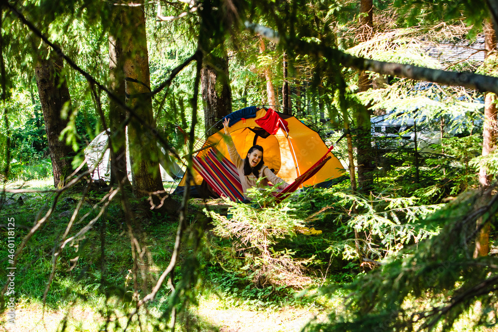 woman laying down in hammock in the forest tent on background