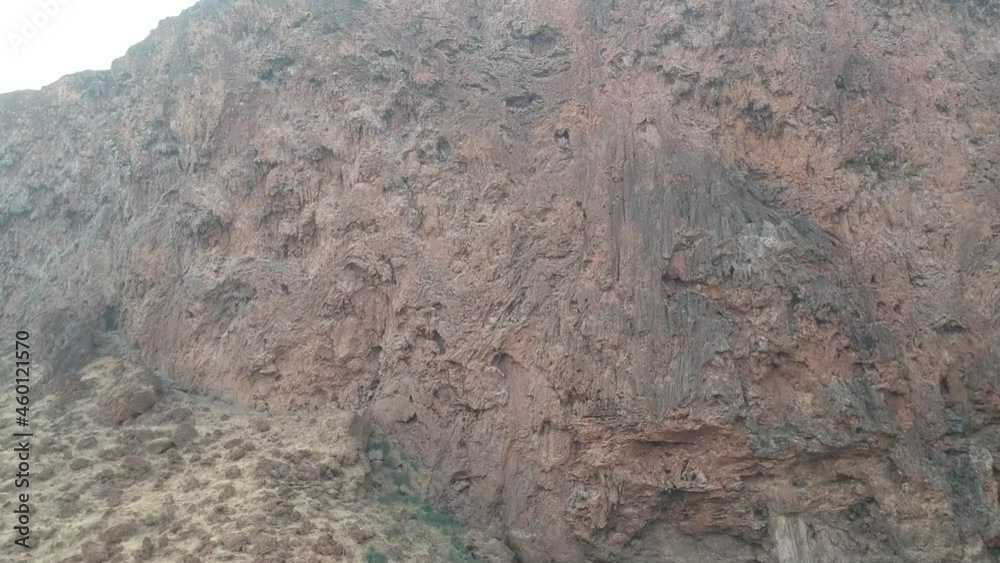 Water erosion patterns on a red-brown cliff face of a dry waterfall camera slowly moving up along the cliff face Aerial Video Water erosion patterns on a red-brown cliff face of a dry waterfall camera slowly moving up along the cliff face Aerial Video