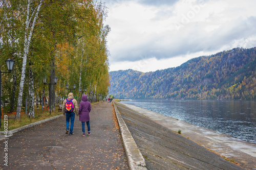People are walking along the city embankment.