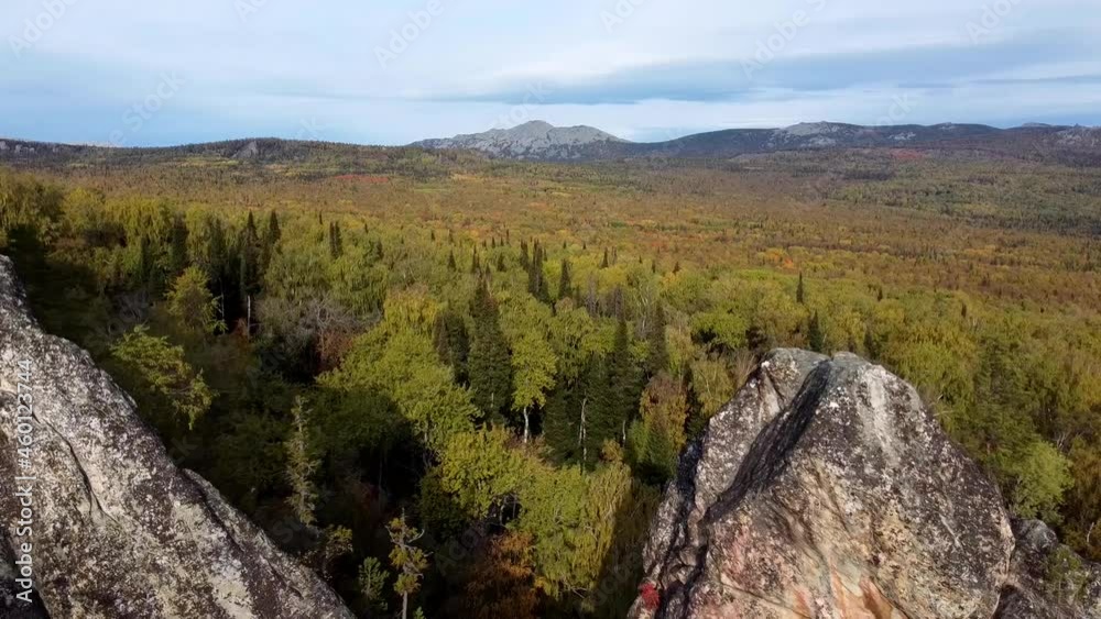 DRON: Flying over the rocks. A breathtaking view from a drone of the Ural mountains of Russia on a sunny autumn day. Take off to the mountains through picturesque landscapes. Eco-travel