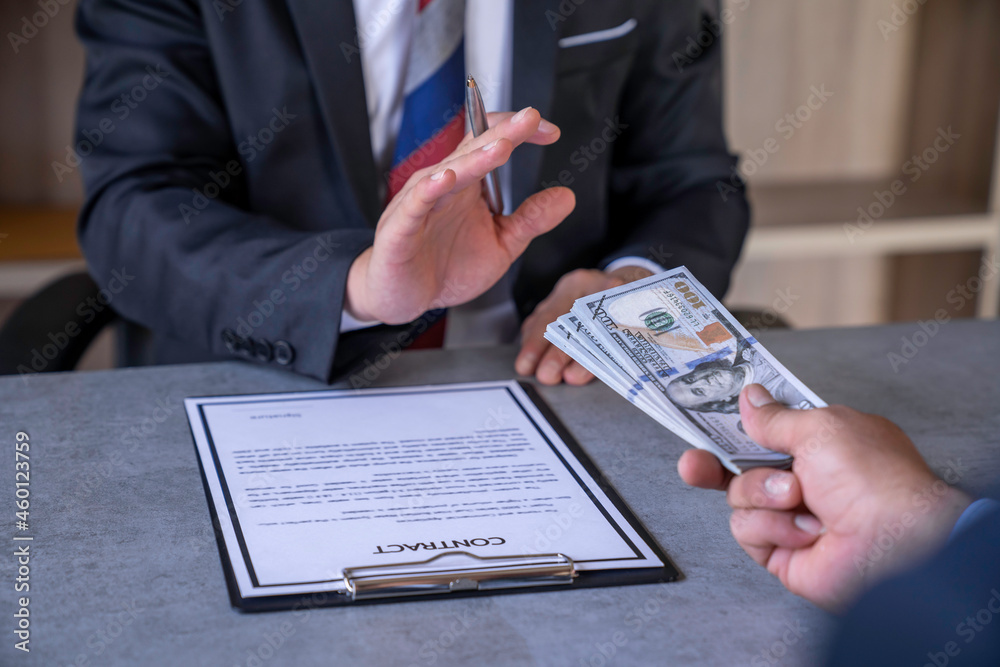 An honest businessman or politician refuses to accept bribes that are given in dollar cash. To do illegal business, corruption in the contracting business, corruption concept and bribery.