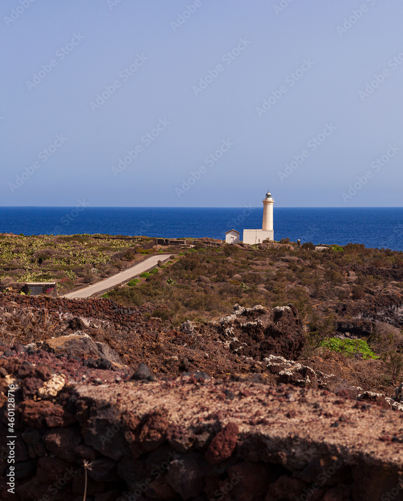 Fototapeta premium View of lighthouse in the scenic lava rock cliff, Linosa