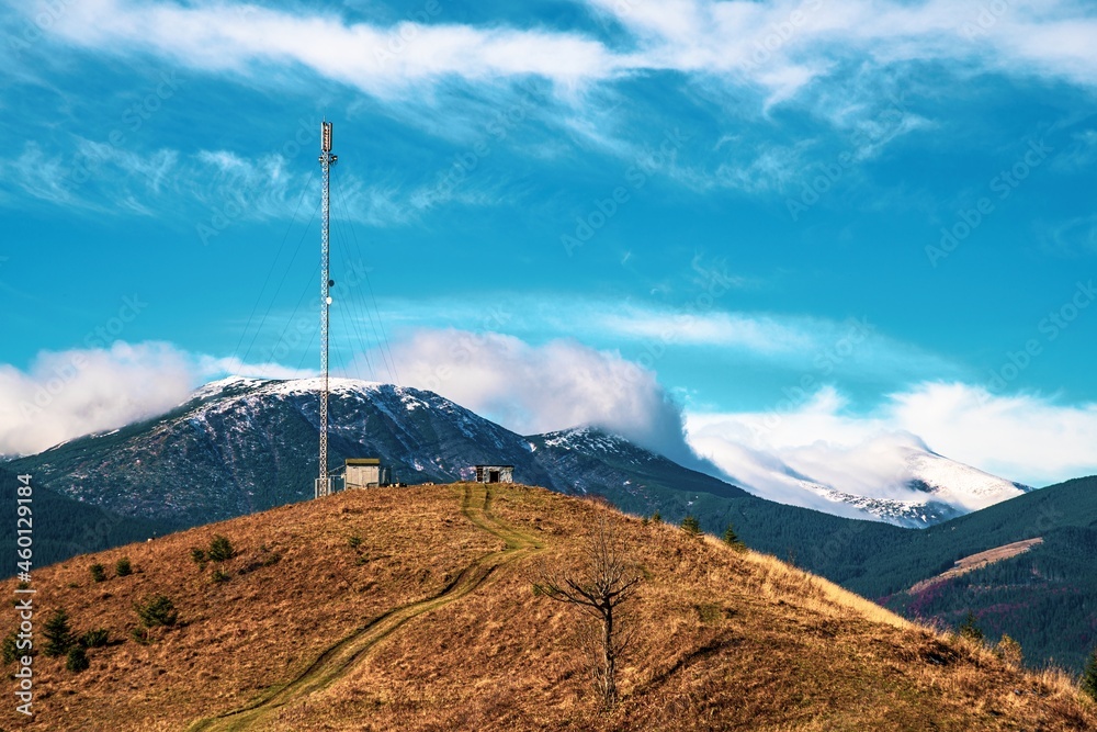 Telecommunication tower against the backdrop of an awesomely beautiful sky with blurry snow-white clouds Telecommunication tower against the backdrop of an awesomely beautiful sky with blurry snow-white clouds
