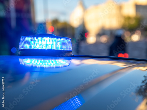 blue lights on the roof of a police car with the background out of focus and lights with bokeh effect	
