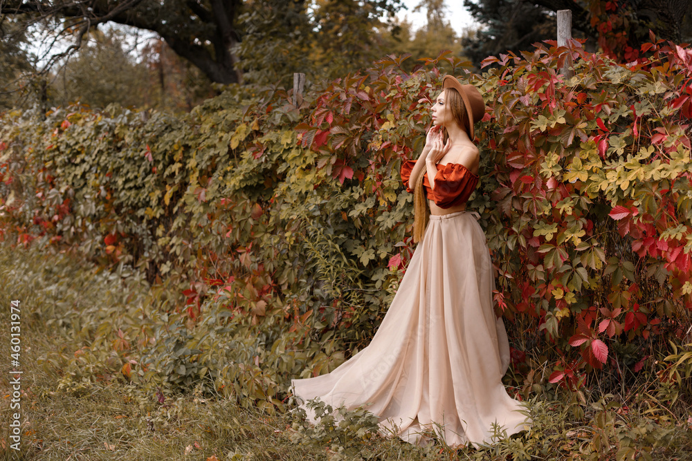 model in a beautiful autumn dress on an autumn background. free space for text.