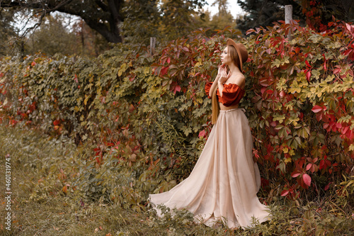 model in a beautiful autumn dress on an autumn background. free space for text.