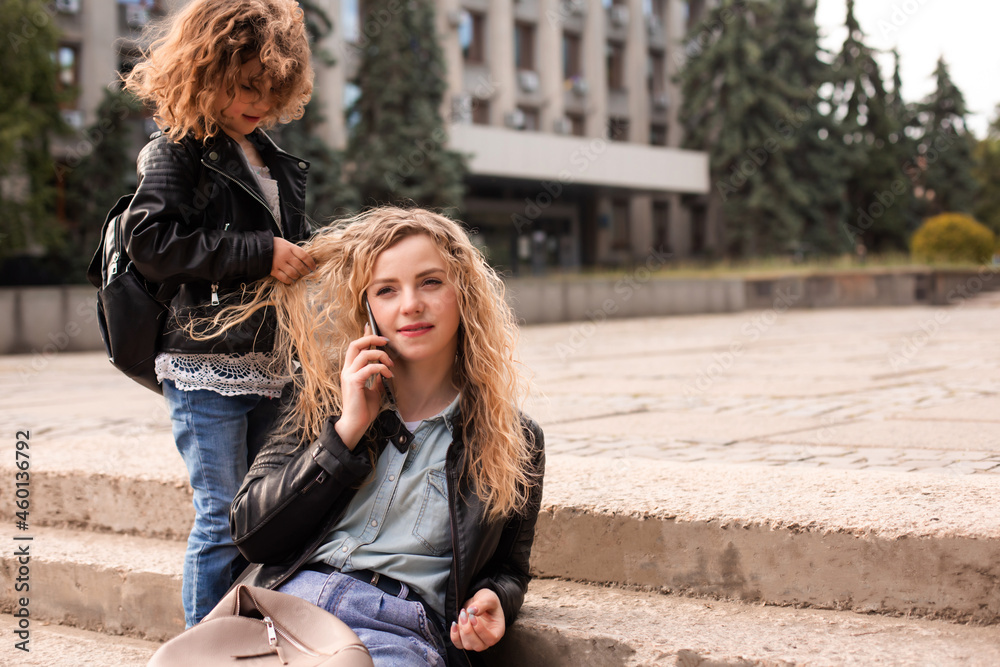 The busy mom with daughter while are walking
