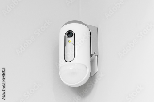 Surveillance camera with presence sensor on the wall photo