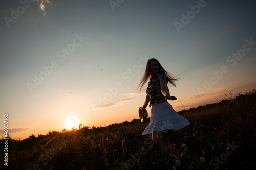 Girl enjoying freedom watching sunset in meadow