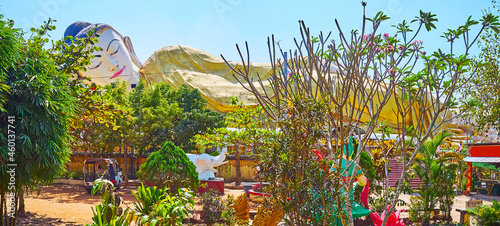 Reclining Buddha through the garden's greenery, Mya Tha Lyaung Buddha Temple, Bago, Myanmar photo
