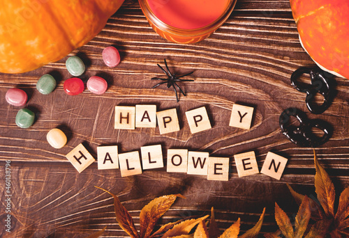 Happy Halloween wooden blocks text, pumpkins, candle, candies on the background
