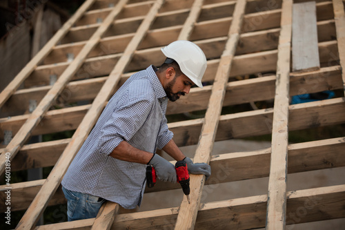 Foto The young builder works on an unfinished roof