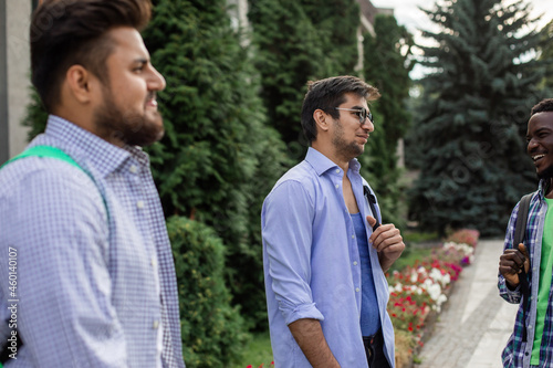 Group of studens stand at the campus and discuss lessons photo