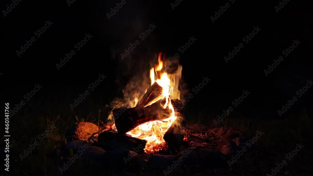 A colorful flaming bonfire with logs burning in the night. Campfire with blazing firewood on the grass fenced with stones
A colorful flaming bonfire with logs burning in the night. Campfire with blazing firewood on the grass fenced with stones