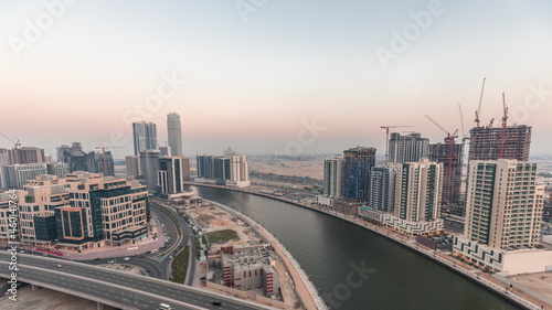 Skyscrapers at the Business Bay aerial day to night timelapse in Dubai, United Arab Emirates