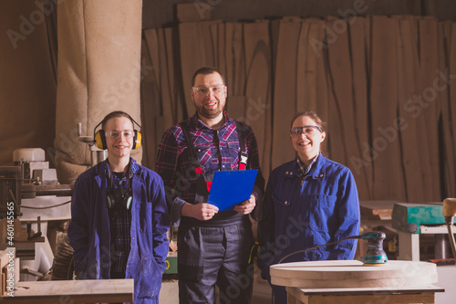 Cheerful carpenter family posing in woodworking workshop
