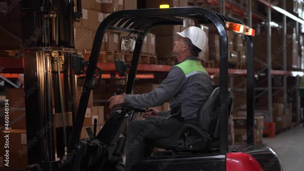 Stockvideo Focused man wearing hard hat working on forklift in factory