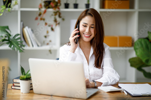 Professional young asian business woman using computer laptop and Talking On Phone Working On Laptop In Modern Office.	