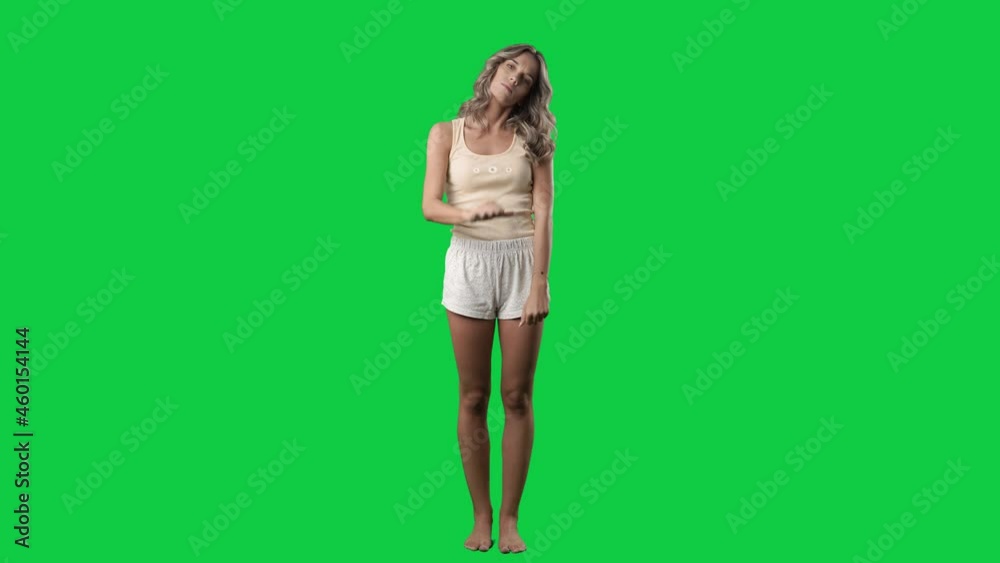 Displeased young cute woman in pajamas showing thumbs down negative gesture. Full body on green screen chroma key background Displeased young cute woman in pajamas showing thumbs down negative gesture. Full body on green screen chroma key background