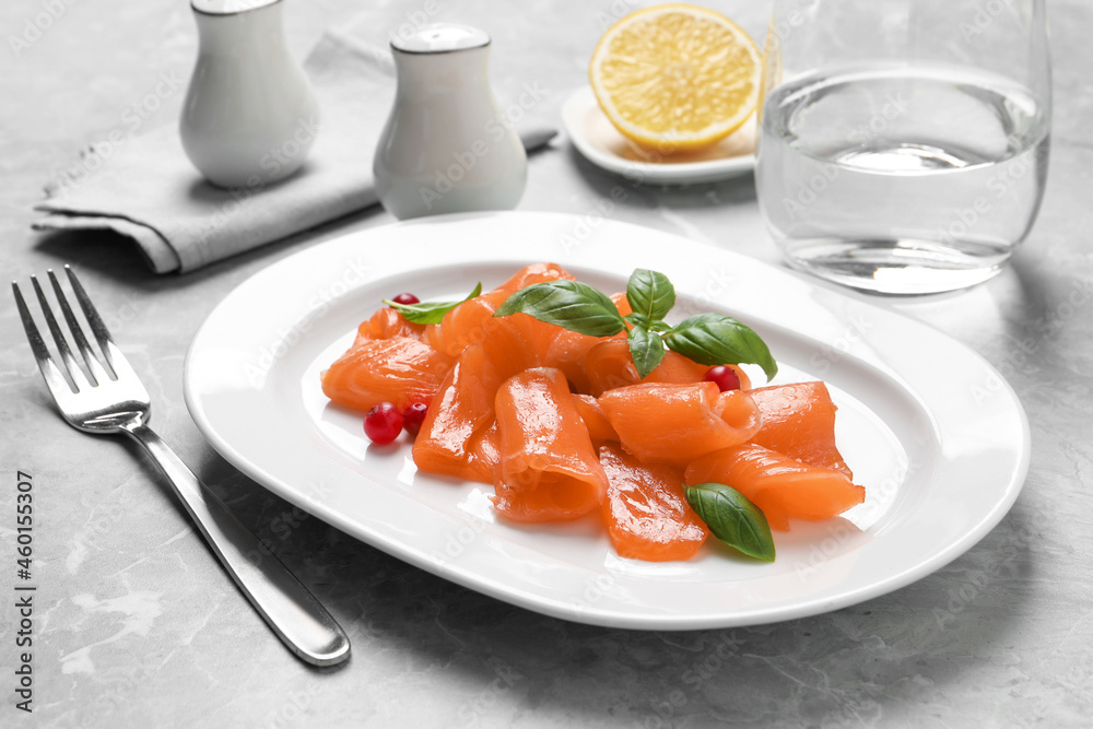 Salmon carpaccio with cranberries and basil served on grey table Salmon carpaccio with cranberries and basil served on grey table