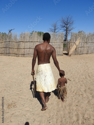 Horizontal shot of black-skinned male and child in African clothes, Mafwe stam in Namibia photo