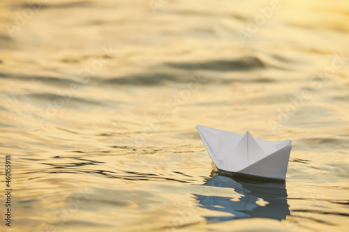 Paper boat floating on water outdoors. Space for text