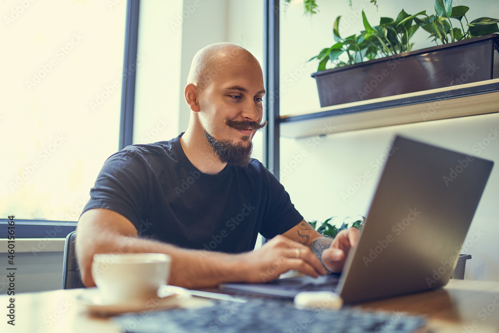 Millennial caucasian man works on computer at home office. Distance Job Millennial caucasian man works on computer at home office. Distance Job