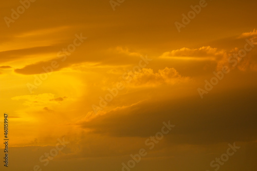 Autumn sky after rain in yellow-orange bright rays of the setting sun.