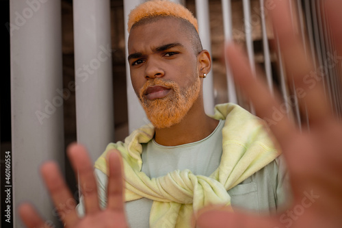 A stylish young man with dyed bearded posing for the camera photo