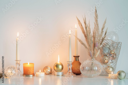 christmas decorations with burning candles in white room