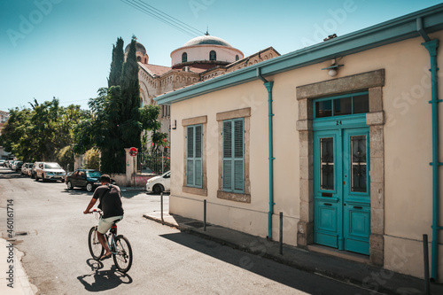 A man rides a bicycle along a narrow street in the city of Limassol, Cyprus