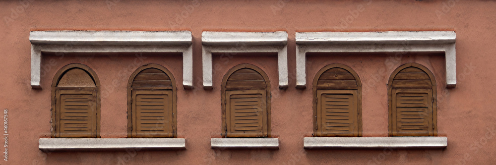 Panorama view of closed wooden shutters on windows of an old building in morocco
