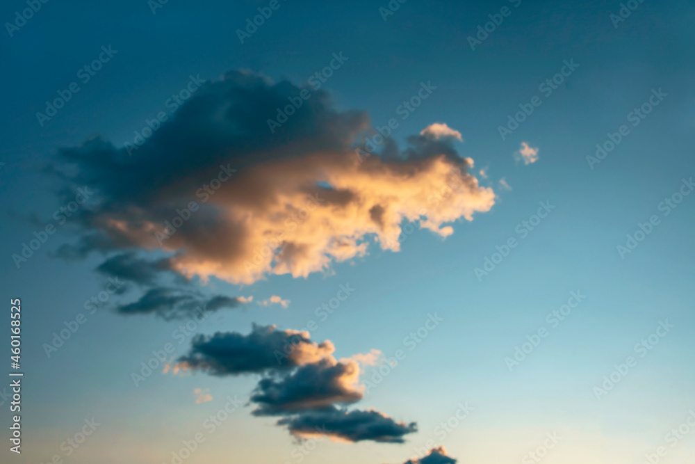 a group of dark cumulus clouds illuminated by the evening setting sun as a natural background