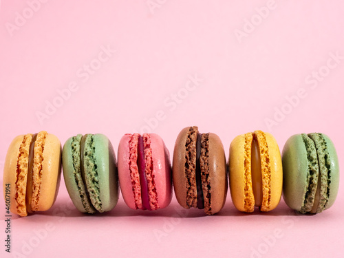 Sweet chocolate macarons, on a pink background.
