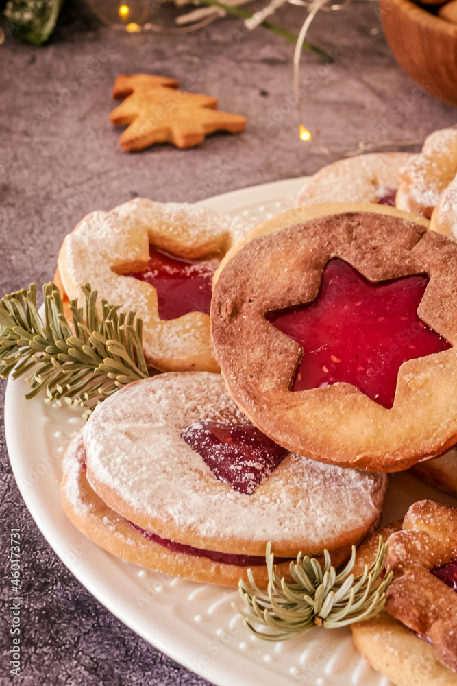 Delicious homemade Christmas cookies with jam, copy space. Traditional Linzer cookies on a dark table, copy space