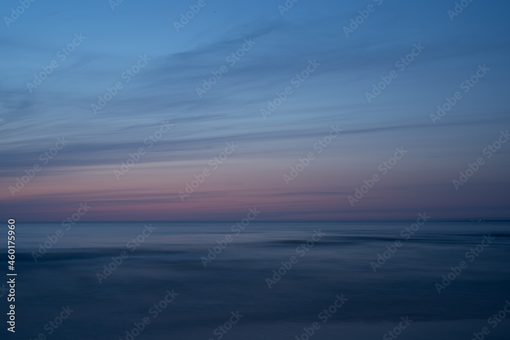 Sunset at sea, light blue sky, dusk