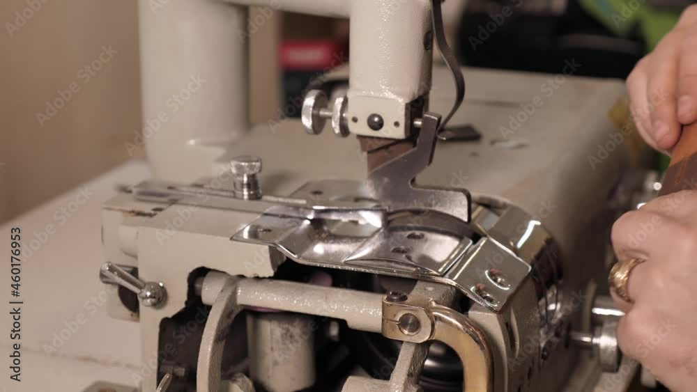 Sewing a leather belt with a sewing machine. Small family business with leather sewing, slow motion, 50 frames per second. Close-up of male hands while working in the workshop Sewing a leather belt with a sewing machine. Small family business with leather sewing, slow motion, 50 frames per second. Close-up of male hands while working in the workshop