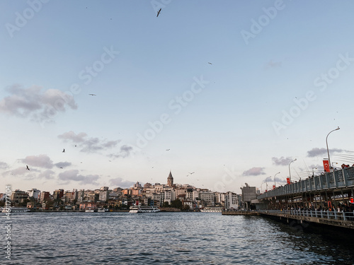 Travel to Turkey. Beautiful view of the Bosphorus Strait at sunset. Panormama overlooking the Galata bridge and Galata tower and many gulls. Postcard view of Istanbul