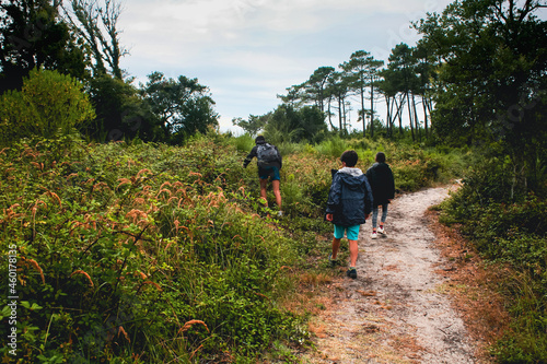 Adolescents et enfant qui randonnent sur un chemin sableux des Landes près du courant d'Huchet
