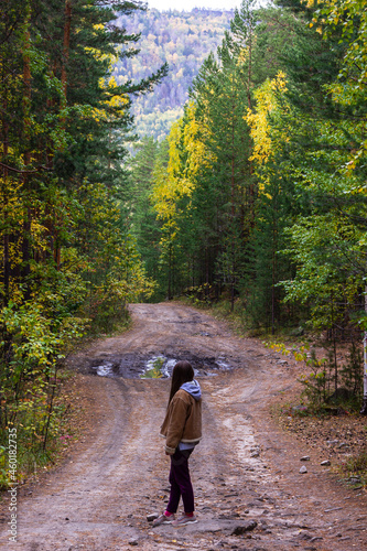 Lonely girl is on a forest road