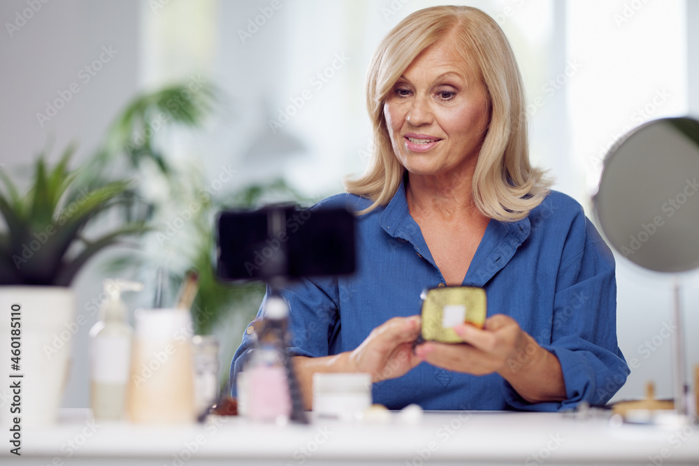 A senior vlogger sitting at home and talking about new beauty products. A senior vlogger sitting at home and talking about new beauty products.