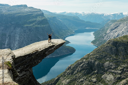 A happy couple standing on the Trolltunga cliff, Vestland county, Norway