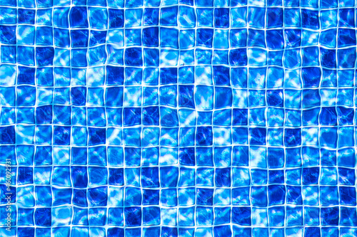 Fundo de uma textura de piscina com a sensação da água em movimento. Estampa em mosaico de pequenos quadrados em diferentes tons de cor azul. Foto em closeup com visão do topo. photo