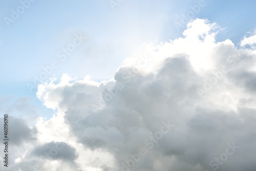 Coudscape. White ornamental clouds. Soft sunlight, sunbeams. Clear blue sky. Natural pattern, texture, background, wallpaper, graphic resources, design, copy space. Symbol of peace photo