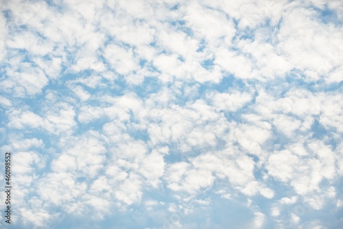 Coudscape. White ornamental clouds. Soft sunlight, sunbeams. Clear blue sky. Natural pattern, texture, background, wallpaper, graphic resources, design, copy space. Symbol of peace photo