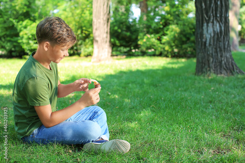 Little boy with snail in park
