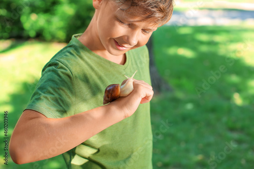 Little boy with snail in park