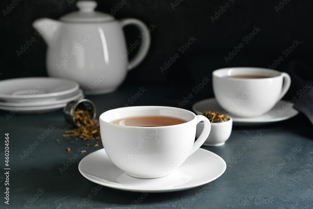 Cups of tasty hojicha green tea on black background Cups of tasty hojicha green tea on black background
